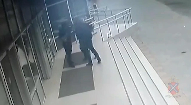 Через секунду мужчина, стоящий ближе к пандусу и спиной к ступеням, рухнет, и больше не встанет | Источник: ГУ МВД России по Волгоградской области