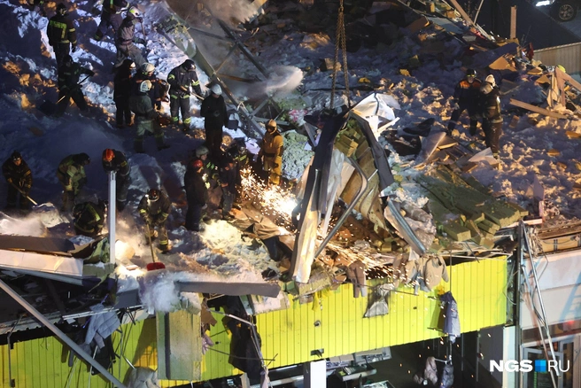 Спасатели распиливают крышу | Источник: Александр Ощепков / NGS.RU