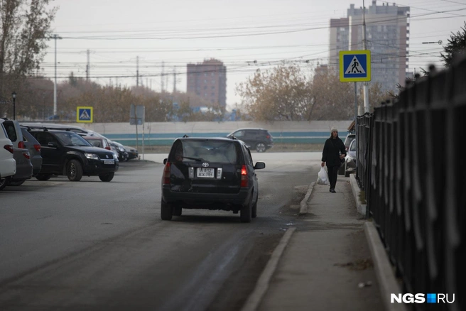 Начинается дорога от улицы Нарымской, здесь еще всё не так плохо: пешеходы теснятся между дорогой и забором, но тротуар есть | Источник: Андрей Бортко / NGS.RU