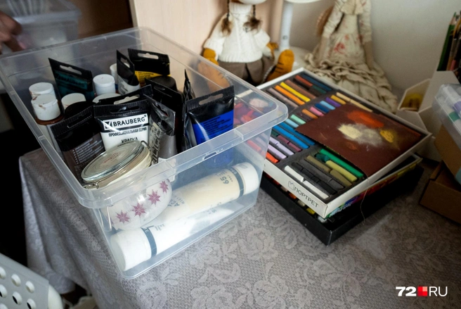 Для росписи кукол она использует акриловые краски и пастель. На фото — малая часть всех тюбиков, баночек и коробок с мелками | Источник: Илья Чикотин / 72.RU