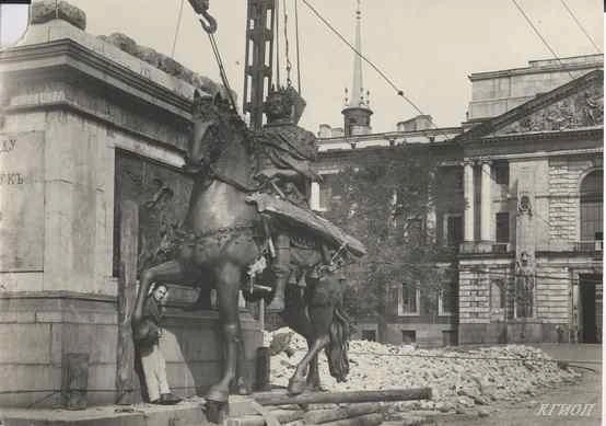 Установка на пьедестал извлеченного из укрытия памятника Петру I у Инженерного замка. У подножия памятника&nbsp;— архитектор А.&nbsp;Э.&nbsp;Гессен. 1945 год. Фотограф Григорьев А.К. | Источник: КГИОП