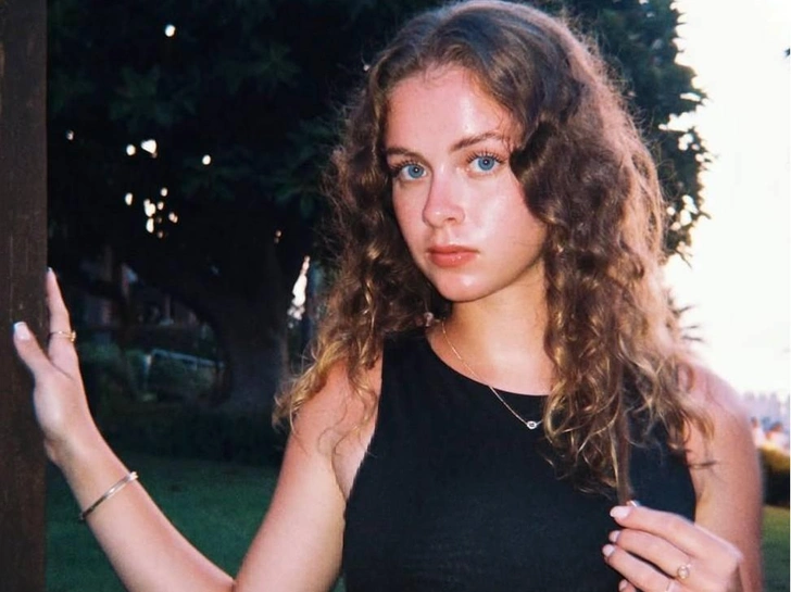 Кискасын жалап жатқан қыздың фотосы