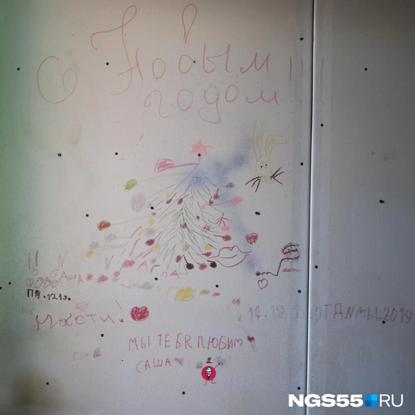 Некоторые стены в доме стали полотнами после расселения, но кое-где они хранят историю жильцов. Глядя на это невольно щемит в груди от осознания: здесь когда-то кипела жизнь, а теперь господствует плесень и гуляет ветер | Источник: Евгений Софийчук / NGS55.RU