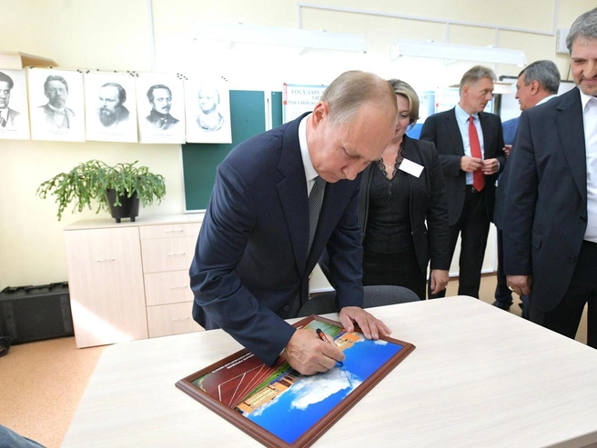 Владимир Путин оставил свою подпись на фотографии школы во время посещения | Источник: Кremlin.ru