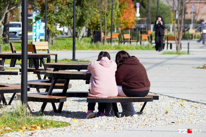 Есть лавочки со столами. Удобно что-то смотреть на телефоне&nbsp;— эти девушки так и делают | Источник: Павел Красоткин / 72.RU 