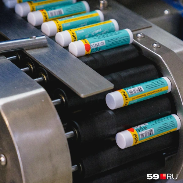 Аппарат быстро наклеивает обертку на каждый стик и отправляет его на ленте в коробку | Источник: Тимофей Калмаков / 59.RU