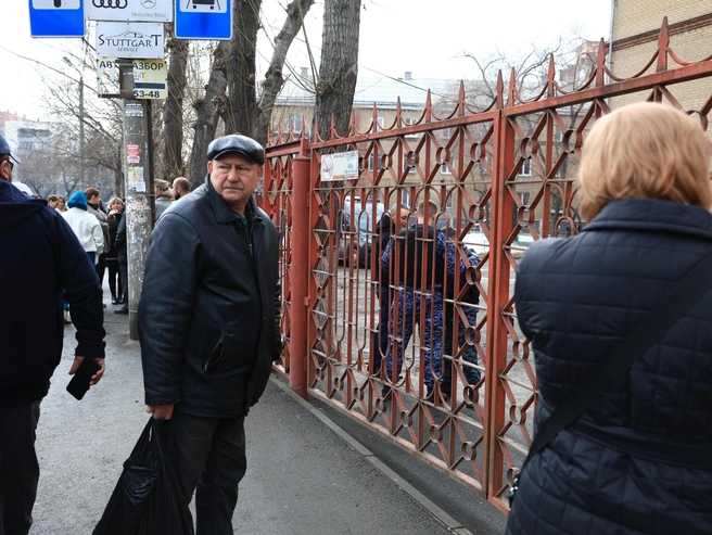 Взрослые с тревогой ожидают выхода детей из здания | Источник: Михаил Шилкин