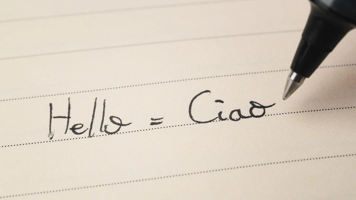 Надпись ручкой на листе бумаги: «Hello=Ciao». | Источник: Shutterstock/Keitma
