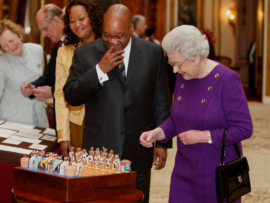 Елизавета II и президент ЮАР Джейкоб Зума рассматривают шахматы, подаренные королеве Нельсоном Манделой, Букингемский дворец, 3 марта 2010 | marieclaire.ru