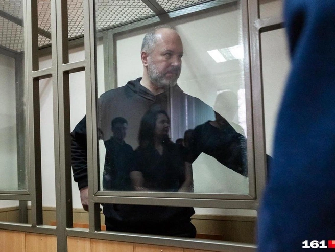 Виталия Кушнарева приговорили к 13 годам за коррупцию и хранение оружия. В отражении на фото — его жена | Источник: Евгений Вдовин / 161.RU