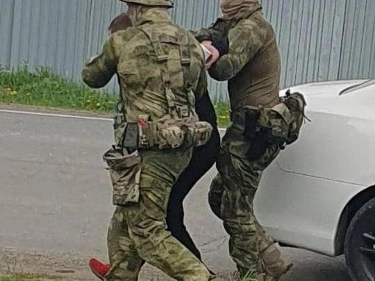 Артура Белых в красных мокасинах конвоируют со связанными за спиной руками | Источник: читатель E1.RU