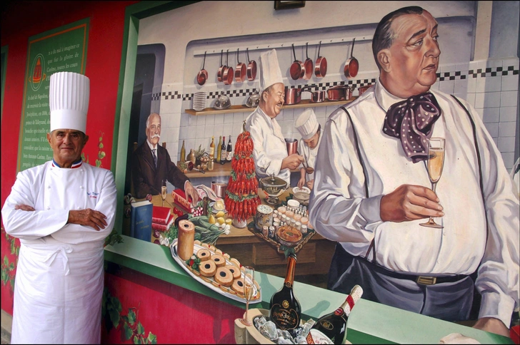Бокюз возле портрета Ферана Пуэна (1897–1955) | Источник: Alexandre MARCHI/Gamma-Rapho via Getty Images