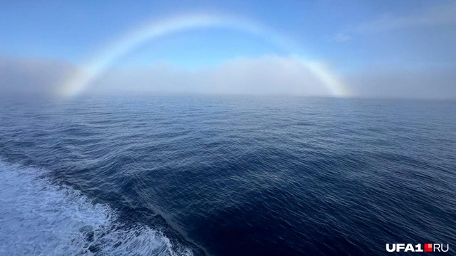 Белую радугу еще называют туманной. Водяные капли, из которых она состоит, меньше дождевых, которые образуют обычную радугу, поэтому лучи света не разлагаются на спектр, а смешиваются, дифракция стирает цвета, делая дугу белой | Источник: Ильдар Салихов