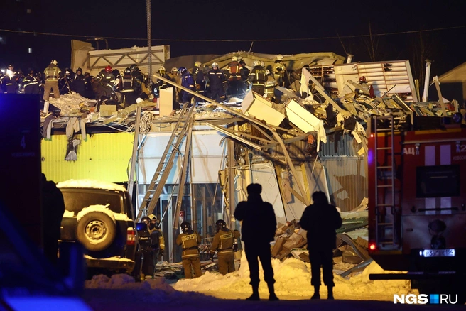Одну из пострадавших укрепили на носилках и спустили с помощью ковша | Источник: Александр Ощепков / NGS.RU