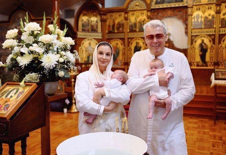 Умиленные Александр и Екатерина Стриженовы обнимают внуков в церкви: фото с крещения