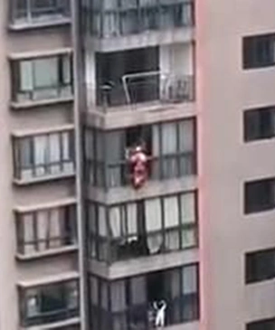 В Китае Человек-пожарный спустился на веревке с 16 этажа, чтобы спасти стоявшую на карнизе девочку (видео)
