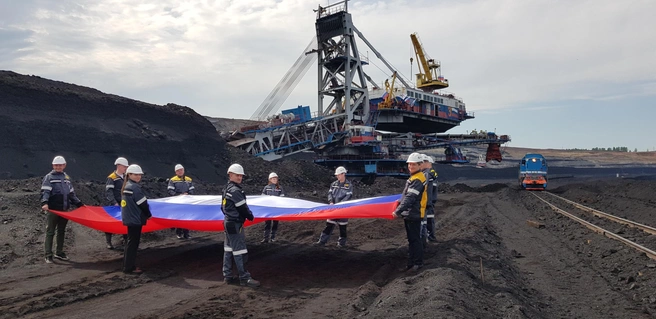 Сотрудники разреза и школьники из трудовых отрядов СУЭК присоединились к флешмобу #ФлагиРоссии, развернув шестиметровое полотно на угольном горизонте | Источник: СУЭК