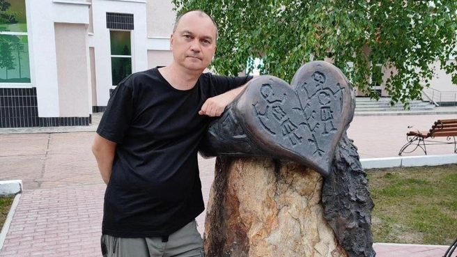 На этом фото Андрей рядом с увеличенным экспонатом Югорского музея — кольцом из мансийского святилища Эсский остров | Источник: Андрей Ермоленко
