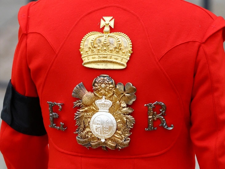 Королевский гвардеец в красной форме с королевским знаком отличия ER в Вестминстерском аббатстве в день государственных похорон Елизаветы II, 19 сентября 2022