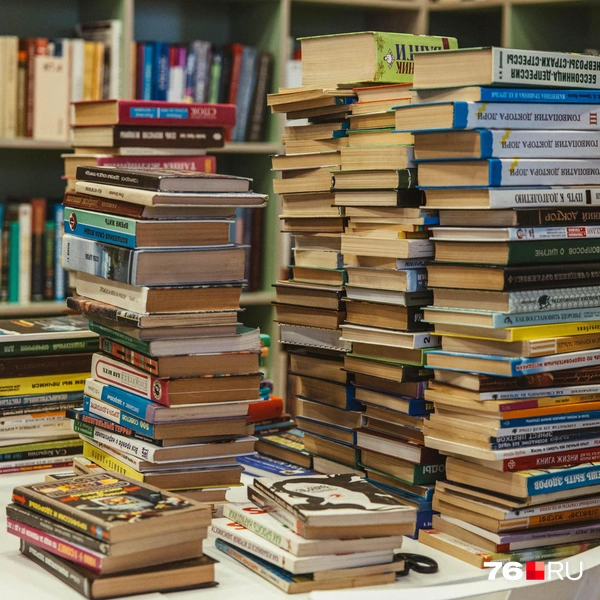 На столе сотрудники перебирают старые книги | Источник: Артем Бауман / 76.RU