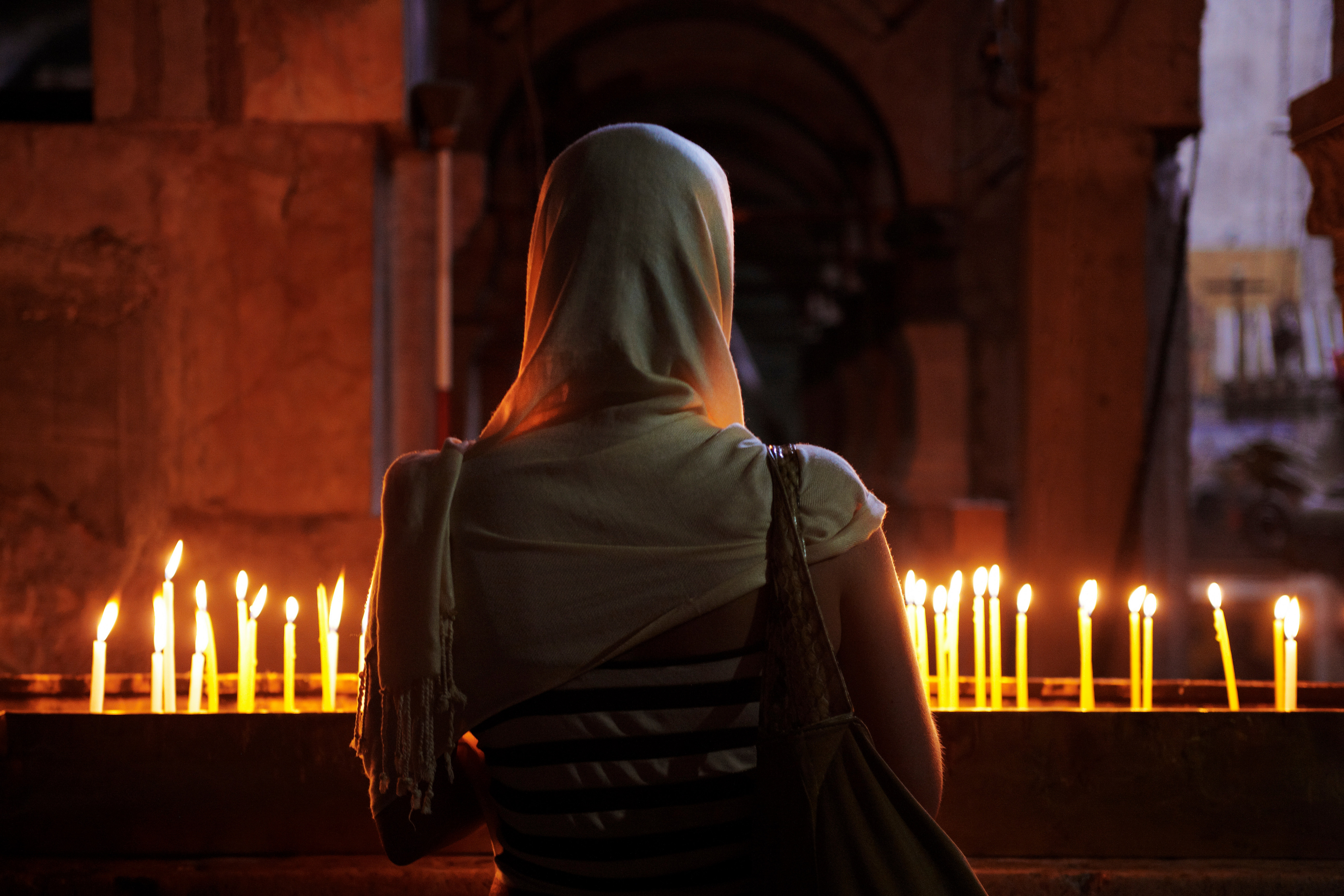 Свечи пояснице. Женщина молится в храме. Молитва в церкви. Девушка в церкви со спины. Девушка в церкви со свечой.