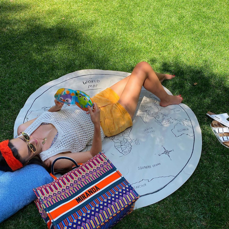 Летнее настроение: Миранда Керр в вязаном топе Nanushka и ярких шортах