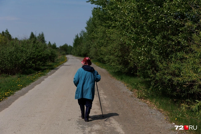 83-летняя пенсионерка говорит, что через мост и по лесу ходить тяжело. Поэтому она надевает сапоги и с мужем идет по воде | Источник: Ирина Шарова / 72.RU