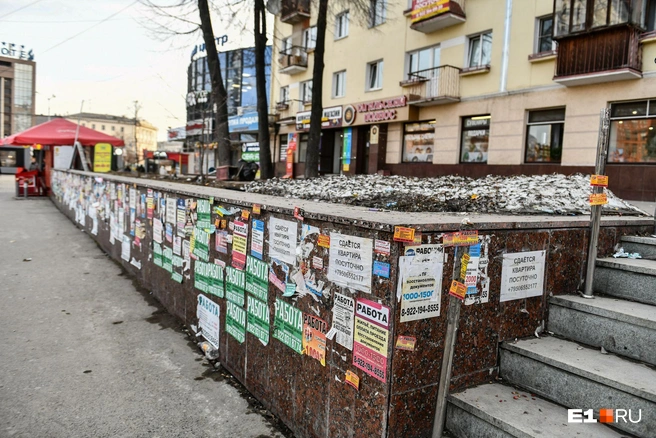 Подпорная стенка давно стала стендом для объявлений. Местами они наклеены в несколько слоев | Источник: Дмитрий Емельянов / E1.RU