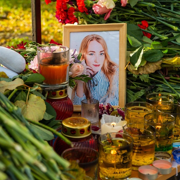 Люди несли свечи и цветы к университету. Кто-то поставил портрет погибшей Ксении Самченко | Источник: Сергей Федосеев / 59.RU