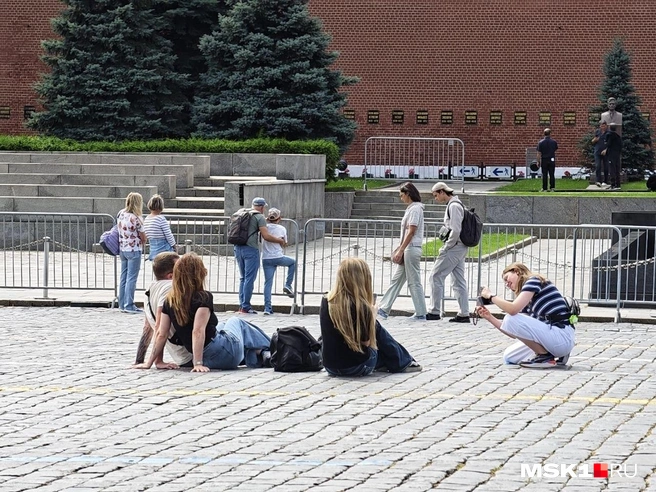 Девушки сели прямо на брусчатку, чтобы сфотографироваться на фоне ГУМа | Источник: Дмитрий Бондарев / MSK1.RU