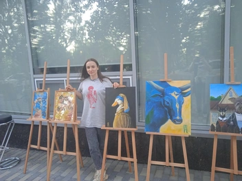 Алина Павлова (Капанадзе) позирует на фоне своих работ | Источник: Денис Гусаков / V1.RU