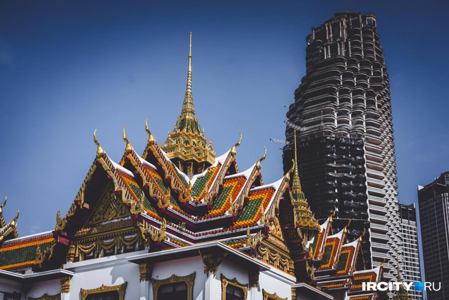 Храм, а на его фоне заброшенный небоскреб. Местные верят, что его населяют духи, и поэтому никак не могут его ни достроить, ни разобрать | Источник: Алина Ринчино / «ИрСити»