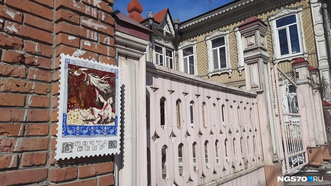 Вторая почтовая марка идеально вписывается в окружающую обстановку. Здесь историческая деревянная застройка с ажурной резьбой | Источник: Анастасия Харламова / NGS70.RU