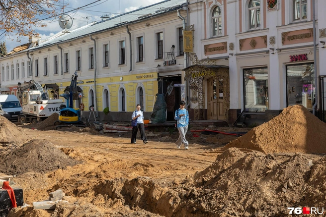 Прохожие смотрят в телефоны, хотя среди этих куч стоило бы глядеть под ноги | Источник: Александр Куренной / 76.RU