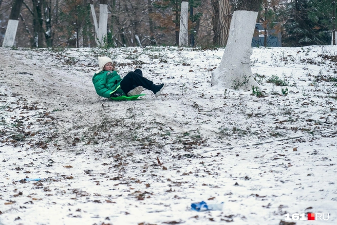 Дети катаются с горок, но снега для этого явно недостаточно | Источник: Евгений Вдовин / 161.RU