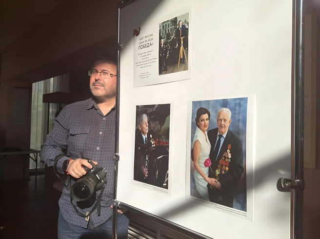 Николай всегда и везде с фотоаппаратом. На фото у стенда своей фотовыставки, посвященной ветеранам ВОВ в художественном музее, 2016 год  | Источник: Предоставлено Николаем Пушилиным
