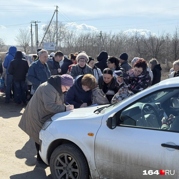 Люди заполняют бумаги прямо на капотах автомобилей | Источник: Сергей Петунин / 164.RU