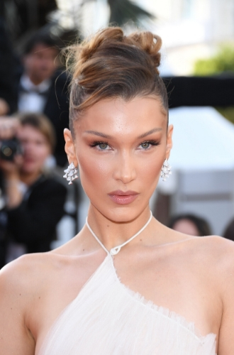 Белла ХадидЕсли вы любите создавать романтичные образы, вам точно придется по душе этот вариант «волнистого» пучка: он будет элегантно смотреться как с платьем, так и с брючным костюмом.