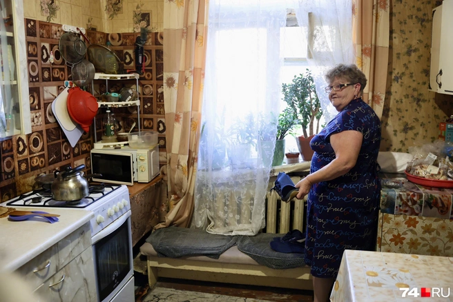 Наталья показывает перекошенный подоконник: один край выше, другой ниже | Источник: Михаил Шилкин