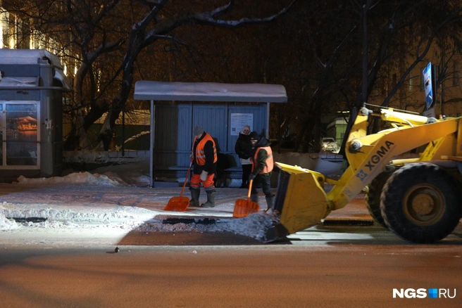 Машины выталкивали валы, а работники зачищали тротуар и прометали его | Источник: Андрей Бортко / NGS.RU