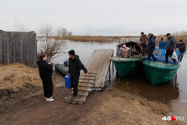 Судно, котрое прикреплено к катеру, местные жители сделали сами. Нужно было больше места для пассажиров и для грузов  | Источник: Ирина Шарова / 45.RU 
