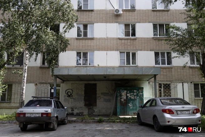 Машины, припаркованные у разных половин здания, такие же разные и одновременно похожие, как эти половины | Источник: Наталья Лапцевич