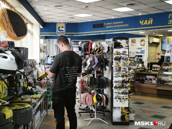 Автолюбитель смотрит товар в магазине при заправке | Источник: Михаил Мечев / MSK1.RU