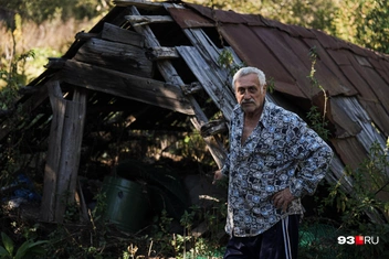 Местный житель на фоне разрушенного сарая | Источник: Дарья Паращенко / 93.RU