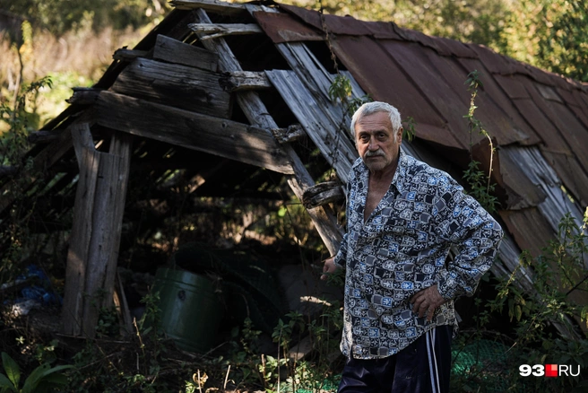 Борис Карапетович на фоне разрушенного оползнем сарая | Источник: Дарья Паращенко / 93.RU