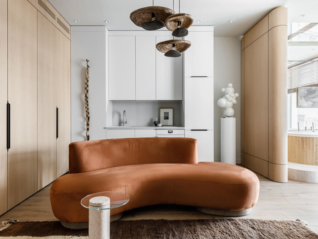 Кухня-гостиная. Подвесные светильники, Ульяна Хохлова. Шкафы и кухня выполнены на заказ, столярная мастерская Владимира Кубышина. Диван выполнен по эскизам дизайнера, мастерская Сергея Корба. Журнальный столик Rosalina, Zuiver, Designboom. Авторская керамика Льва Ефимова. На стене слева — кора мексиканского дерева, галерея Buro All Design. | Источник: Александр Володин. Стиль: Татьяна Гедике