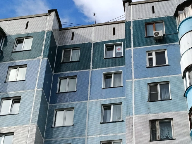 Жители МЖК и Плющихинского жилмассива стали вывешивать в окнах красные кресты в знак поддержи поликлиники на Лазурной, 20/1 | Источник: Марина Павловская