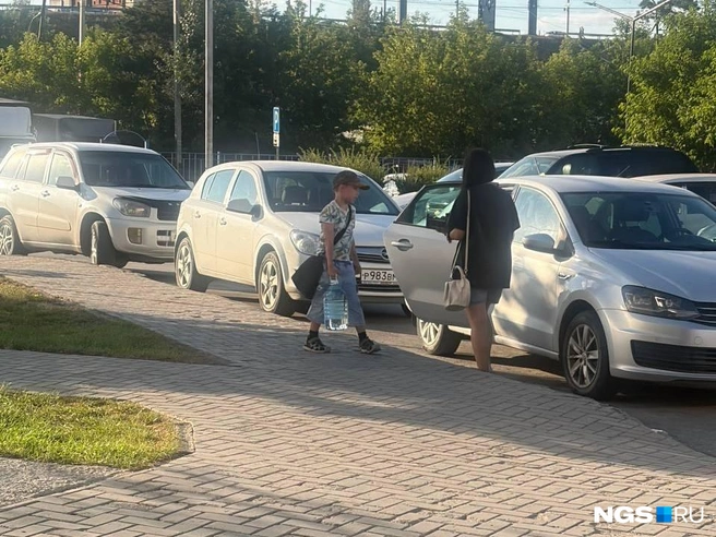 Многие возвращаются домой с купленной водой | Источник: Настасья Медведева/NGS.RU