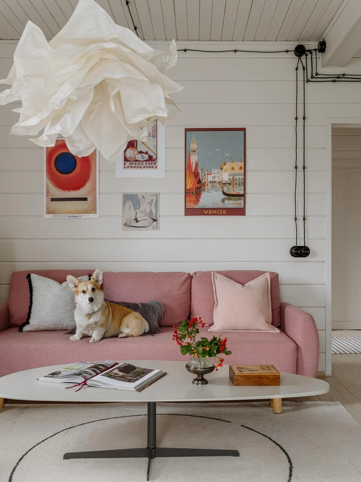 На журнальном столике ваза с дырочками под каждый цветок букета, купленная на блошином рынке в Париже. На диване сидит любимица семьи — корги Арлетт | Источник: Ольга Шангина; стиль: Яна Яхина