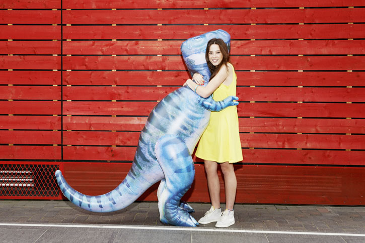 Девушка обнимается с динозавром